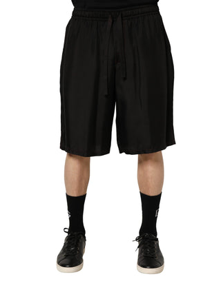 Person wearing black shorts on a white background
