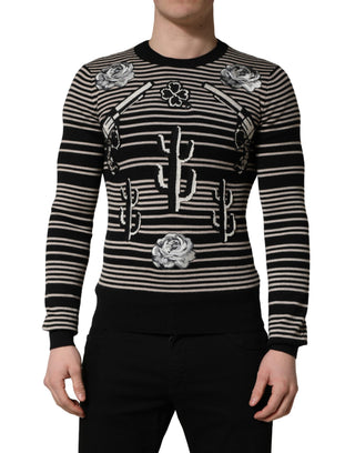Black and white striped sweater with decorative elements worn by a person on a white background