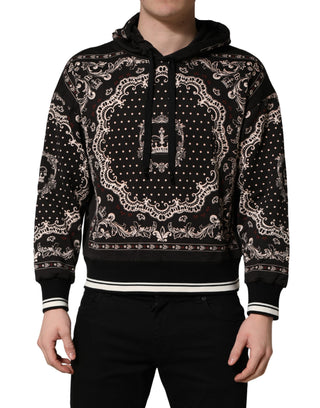 Black hoodie with intricate white patterns worn by a person on a white background