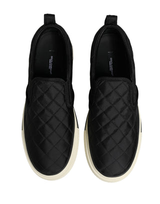 Black quilted slip-on shoes on a white background