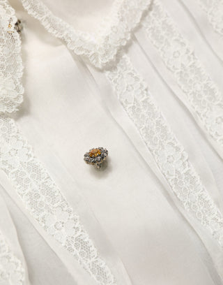 Blusa blanca de seda transparente con volantes y botones