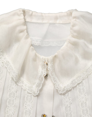 Blusa blanca de seda transparente con volantes y botones