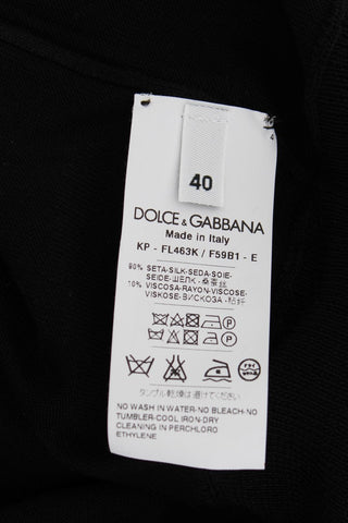 Top de polo de seda negra con bordado floral