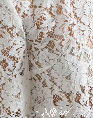 Blusa blanca de algodón con encaje floral y cuello redondo
