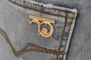 Jeans slim fit de algodón con lavado azul desgastado