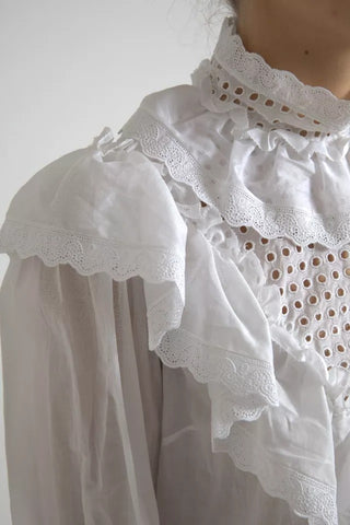 Blusa blanca de algodón con cuello alto y encaje