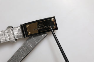 Cinturón clásico plateado con placa dorada con logo  