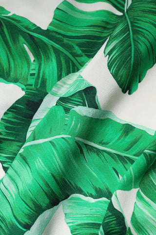 Pantalones blancos de talle alto con hojas verdes