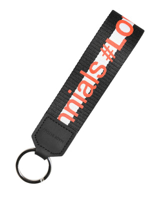 Llavero porta llaves de latón plateado con logo negro y poliéster