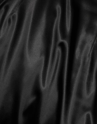Vestido midi negro de satén con mangas cortas tipo capa y corte ajustado