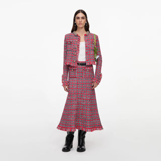 Woman wearing a red and black plaid outfit on a white background