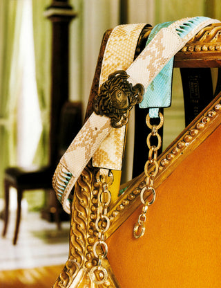 Decorative ribbon with gold chain on a chair in an elegant room.