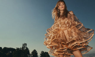 Woman in a flowing dress against a clear sky